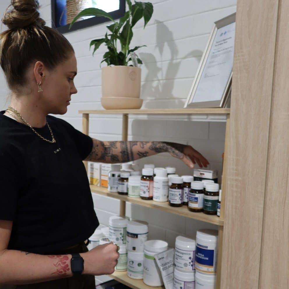 Alanna at the dispensary shelf selecting a supplement.